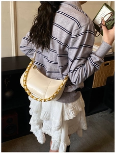 Detail of white half-moon hobo bag with vintage wax leather texture and gold chain link