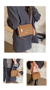 Detail view of brown vintage satchel with gold lock and cute teddy bear pendant charm