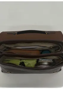 Macro view of brown leather handbag interior with three compartments and gold hardware