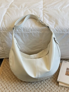 Sac hobo beige minimaliste avec bandoulière réglable et détails de fermeture éclair argentés