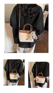 Dettaglio della borsa a secchiello beige e marrone con finiture a contrasto e coniglio