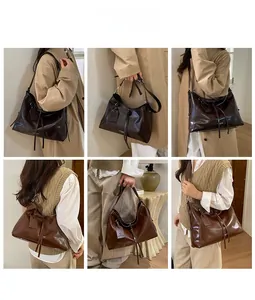 Close-up of large glossy leather tote bag with drawstring detail and adjustable strap
