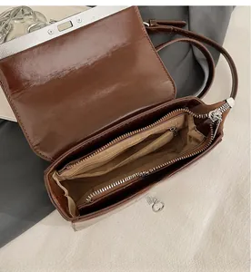 Detailed interior view of a brown matte leather bag showing zipper compartments and layers