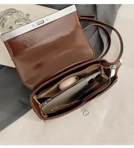 Interior view of brown faux leather shoulder bag showing zipper pocket and storage capacity
