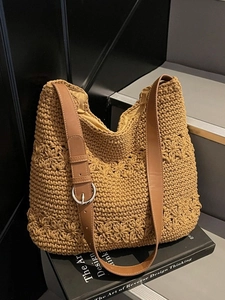 Handmade crochet tote bag with floral patterns and leather strap on minimalist background