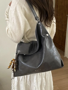 Deep grey slouchy tote bag with silver eyelets and colorful tassel charm for women
