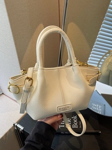 Chic white litchi pattern bucket bag with gold hardware and adjustable strap