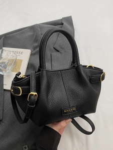 Chic black lychee leather bucket bag with gold hardware and removable shoulder strap