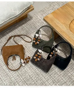 Detail of vintage matte leather half-moon handbags in four colors with charm tassels
