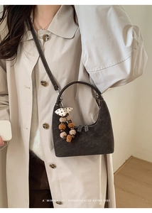 Detail view of dark brown crescent bag with retro charm and long adjustable shoulder strap