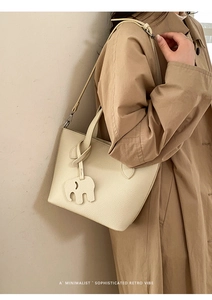 Gros plan d'un sac cabas en cuir beige avec grain lychee et charm éléphant mignon