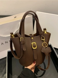 Classic dark brown lychee leather bucket bag with an elephant charm and gold hardware