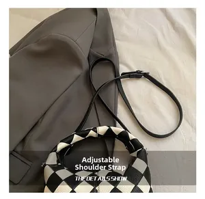 Détail de la bandoulière réglable et de l'anse tressée du sac à damier noir et blanc