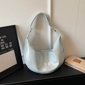 Close-up of light blue dumpling bag with glossy leather texture and pleated details