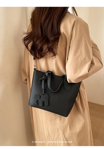 Détail du sac panier en cuir litchi noir avec breloque éléphant iconique
