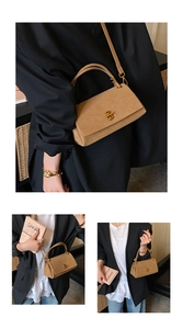Detail of khaki suede crossbody bag with vintage golden metal lock and leather handle