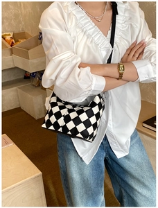 Détail du sac à bandoulière damier montrant la texture cuir et la fermeture éclair