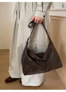 Detail view of large dark brown leather hobo bag with adjustable strap and silver buckle