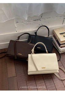 Close-up of vintage leather texture and gold metal logo plaque on the elegant handbags