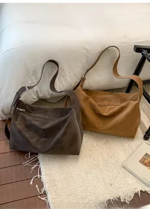 Close-up of suede hobo bags in dark coffee and camel with adjustable wide straps