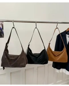 Detailed display of hobo bags in dark brown, black, and caramel colors on a metal rack