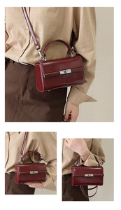 Detail of burgundy patent leather handbag featuring a metallic twist lock and top handle
