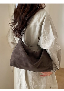 Retro dark brown hobo shoulder bag styled with a minimalist trench coat in detail
