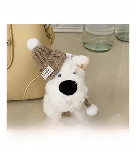 Close-up of cute plush dog charm with brown knitted hat and scarf for handbags