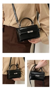 Detail of black glossy patent leather mini square bag with silver metal lock buckle