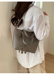 Détail du sac cabas gris en cuir litchi avec breloque éléphant et bandoulière réglable