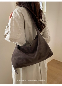 Deep brown minimalist faux suede hobo bag with large capacity shown on shoulder
