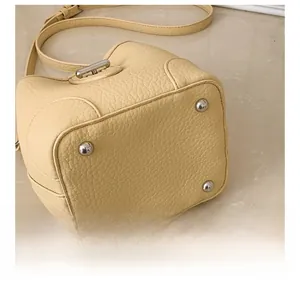 Detail view of the bottom leather and four protective silver metal feet of bucket bag