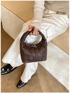 Détail du tissage en cuir et de la fermeture éclair argentée sur le sac à main marron