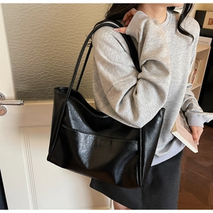 Dettaglio borsa shopper in pelle PU nera lucida con capiente tasca frontale esterna