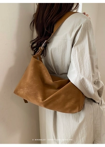 Side view of a minimalist brown suede-like shoulder bag styled on a beige outfit