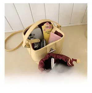 Internal capacity of beige bucket bag showing storage space for cosmetics and essentials