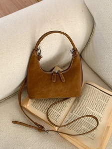 Vintage caramel brown hobo bag in soft suede with silver hardware on open book