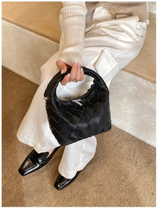 Gros plan sur le tissage noir et la fermeture éclair argentée du sac compact moderne