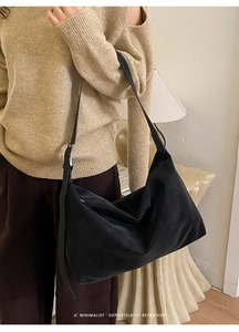 Detail showing high-capacity black minimalist tote bag with adjustable leather strap