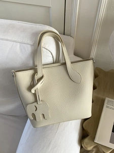 Sac cabas crème en cuir grainé avec charme éléphant sur plateau en bois décoratif