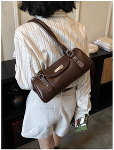 Close-up of a vintage dark brown leather boston bag with metal buckle and dual straps