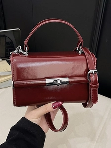 Elegant dark red patent leather handbag with silver metallic clasp and top handle
