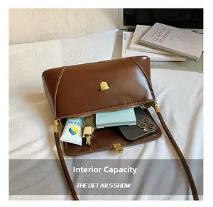 Internal capacity of brown leather baguette bag showing storage for phone and cosmetics