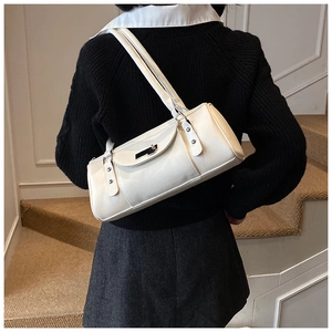 Detail of a creamy white cylindrical shoulder bag with double straps and silver metal buckle
