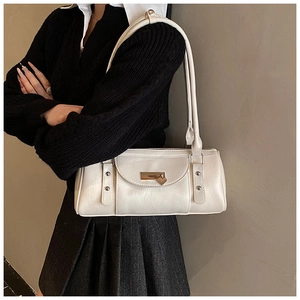 Detail of a beige Boston shoulder bag featuring a silver heart-shaped pendant on the front