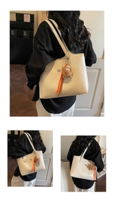Détail d'un sac cabas en similicuir blanc crème avec un charmant monstre en peluche