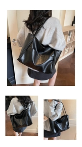 Primo piano di una borsa tote nera in pelle con tasche frontali funzionali e design minimalista