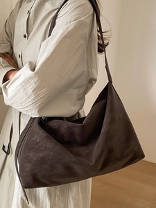 Minimalist large brown faux suede shoulder bag shown on a model for a casual elegant look