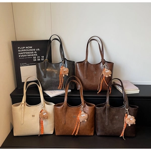Détail de cinq sacs cabas vintage en similicuir avec des breloques de monstres en peluche