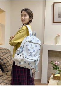 Détail du sac à dos scolaire avec charm panda et motifs cœurs dans un décor intérieur